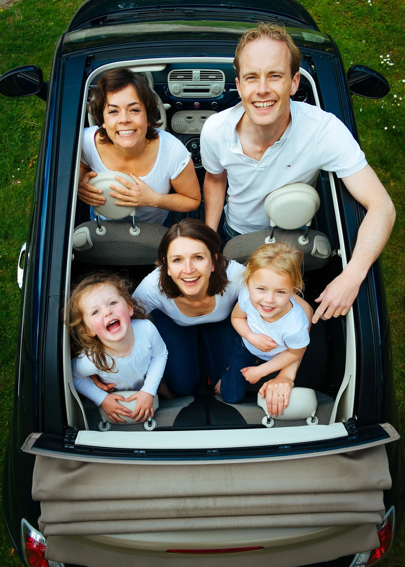 A happy family together on a car looking up